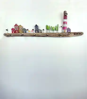 Percheiro artesanal con faro e pequenas casas